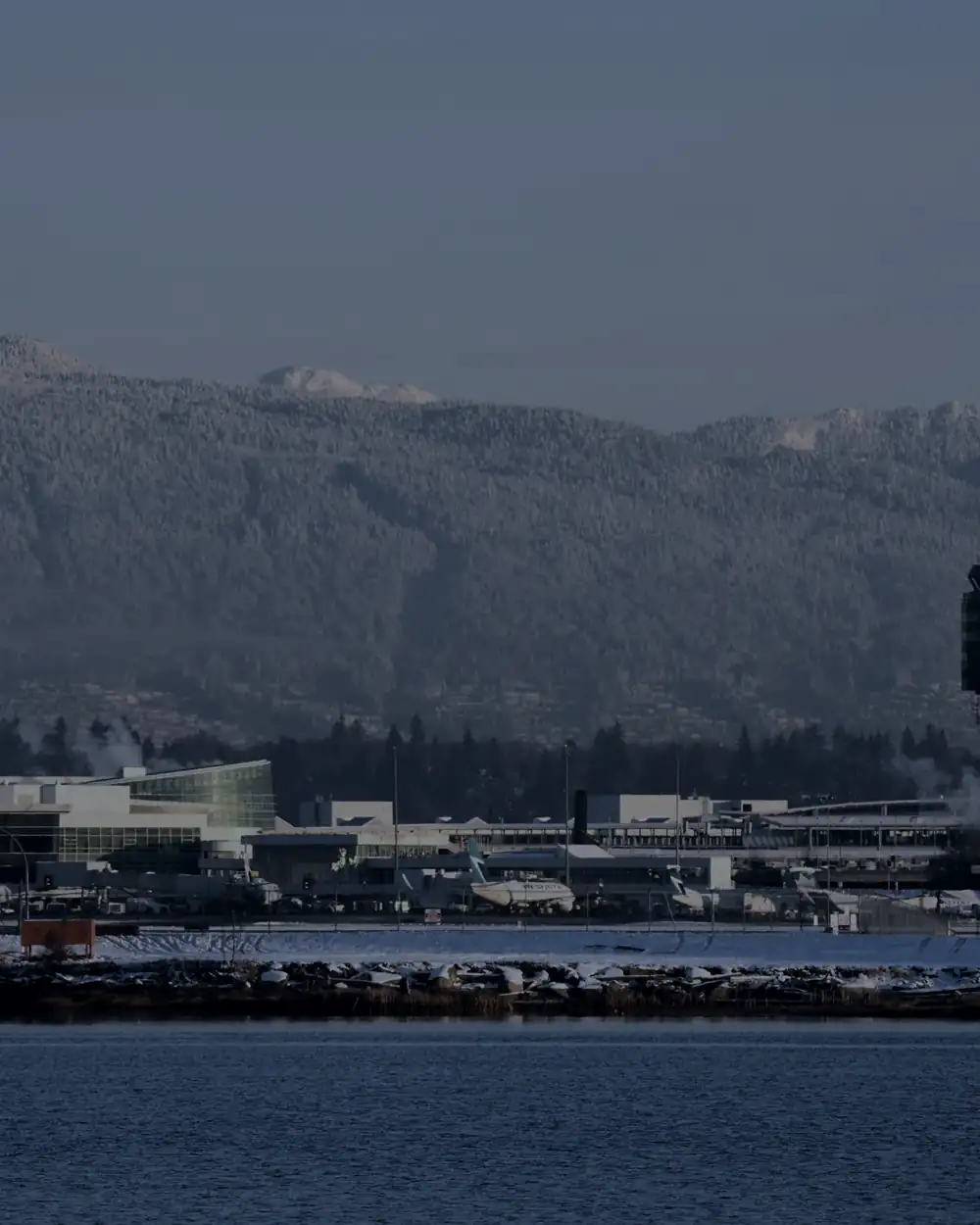 Vancouver International Airport control tower with the North Shore mountains behind