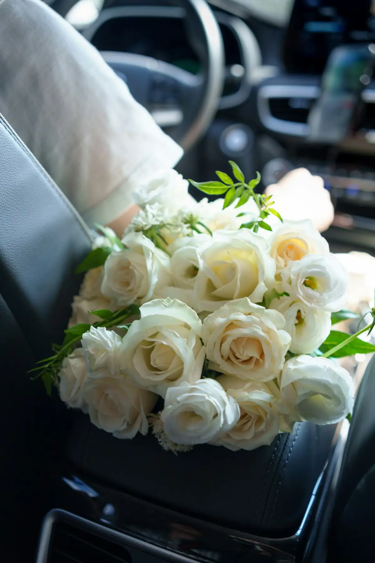 Bouquet of white roses resting on a car seat