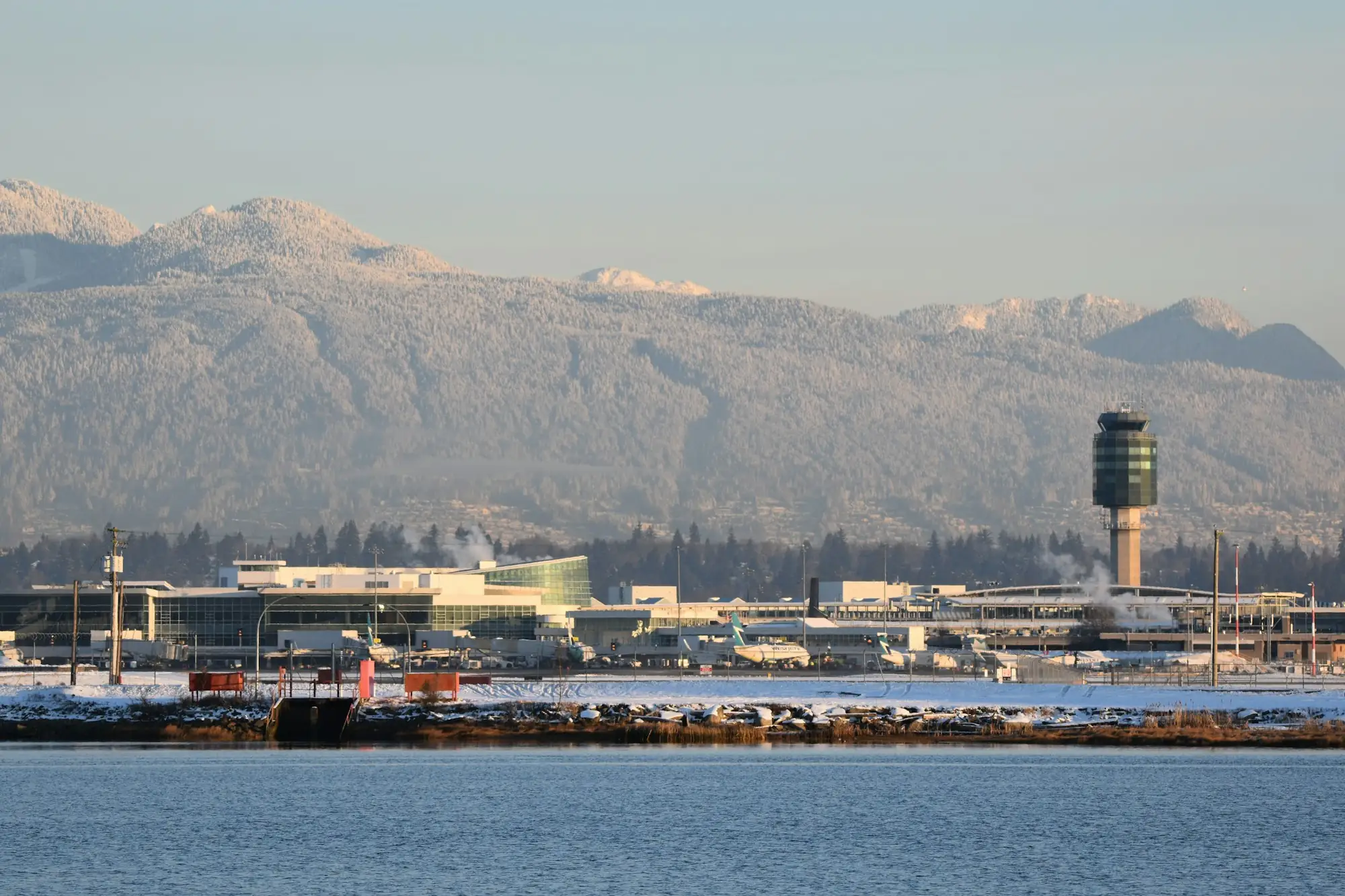 Vancouver International Airport control tower with snow-capped North Shore mountains behind